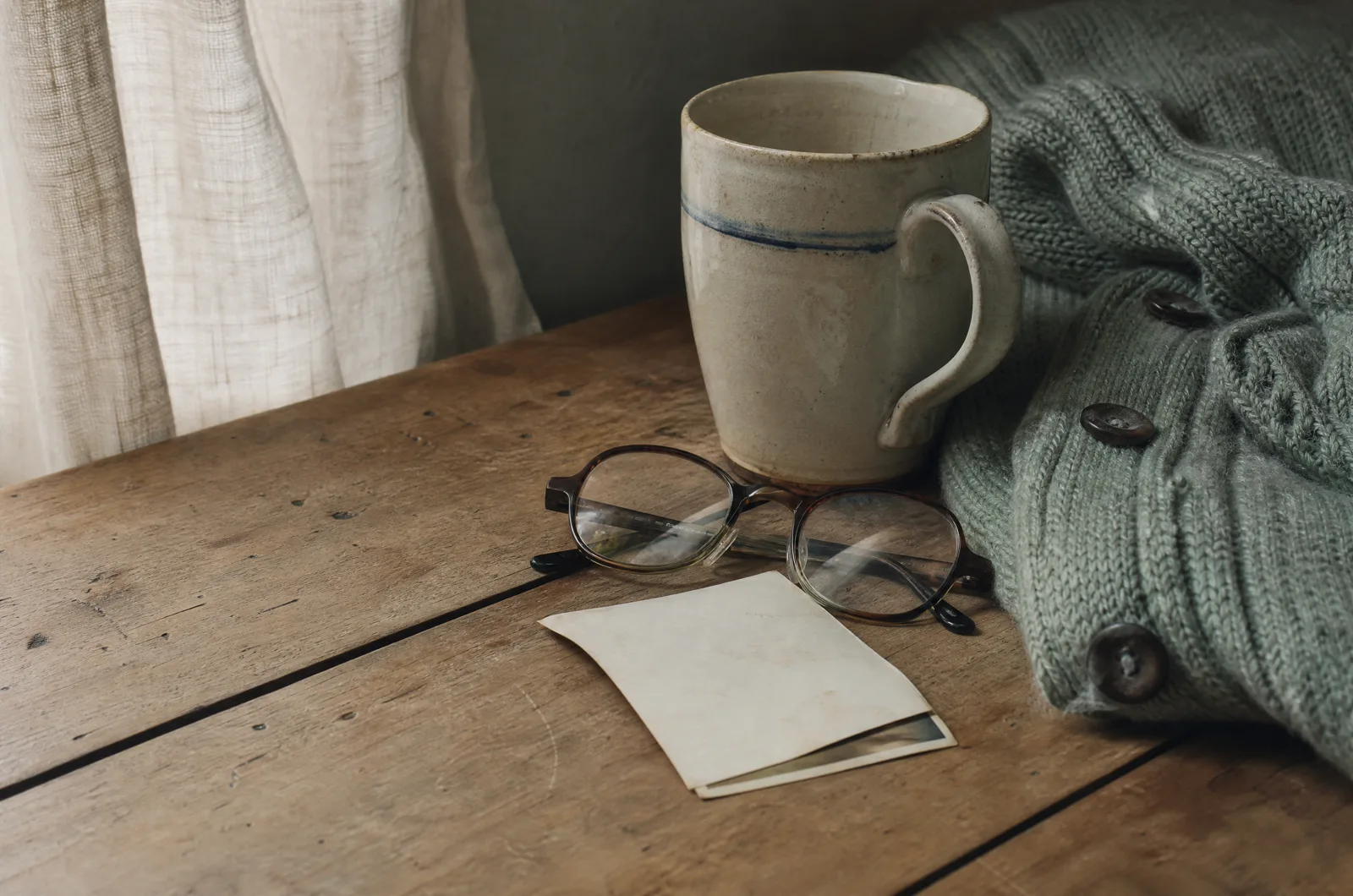 Photographs, a handwritten letter and familiar keepsakes on a table